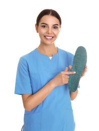 Photo of Female orthopedist showing insole on white background