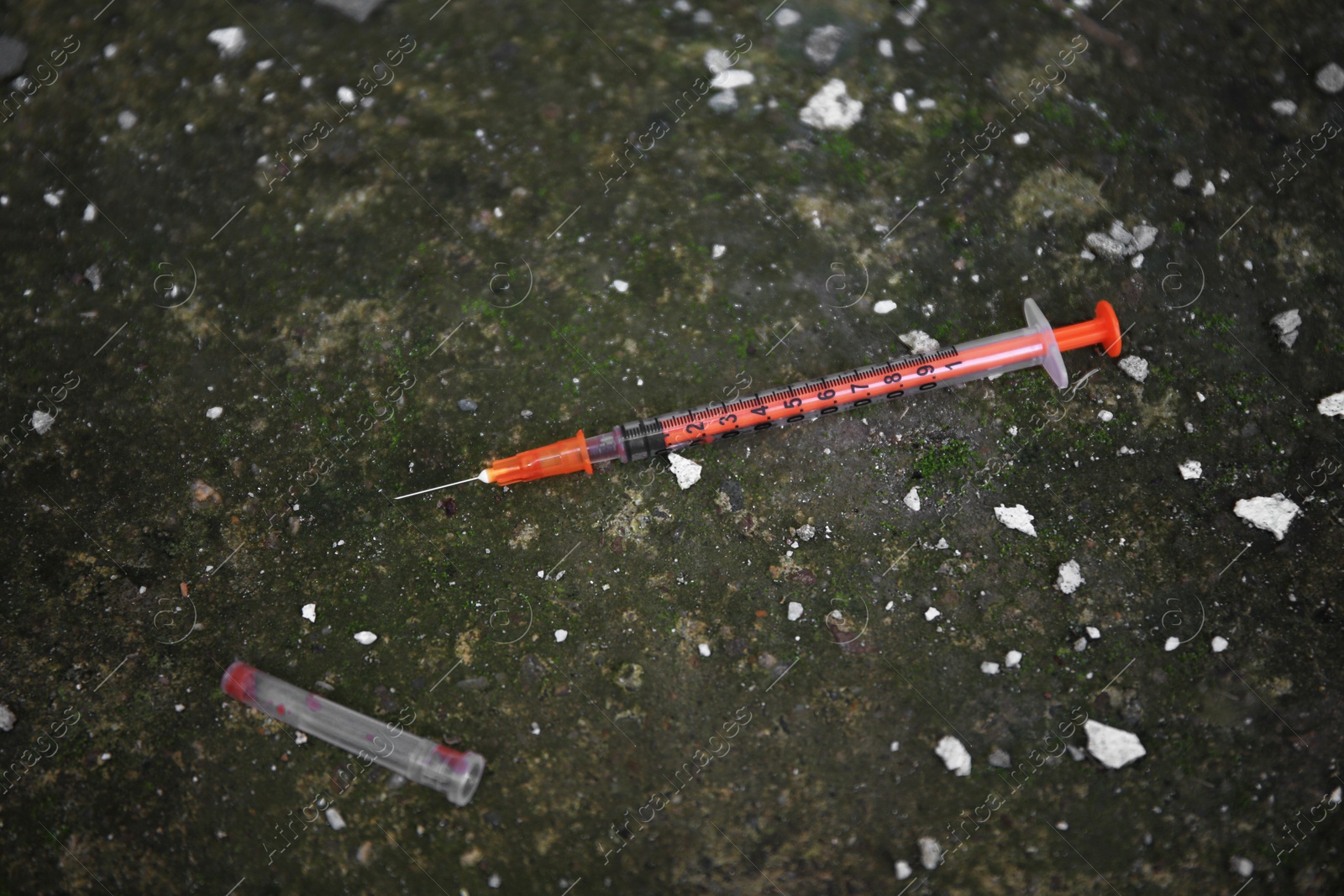 Photo of Empty disposable syringe with needle on street