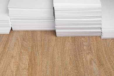 Photo of Stacks of white paper sheets on wooden table, space for text