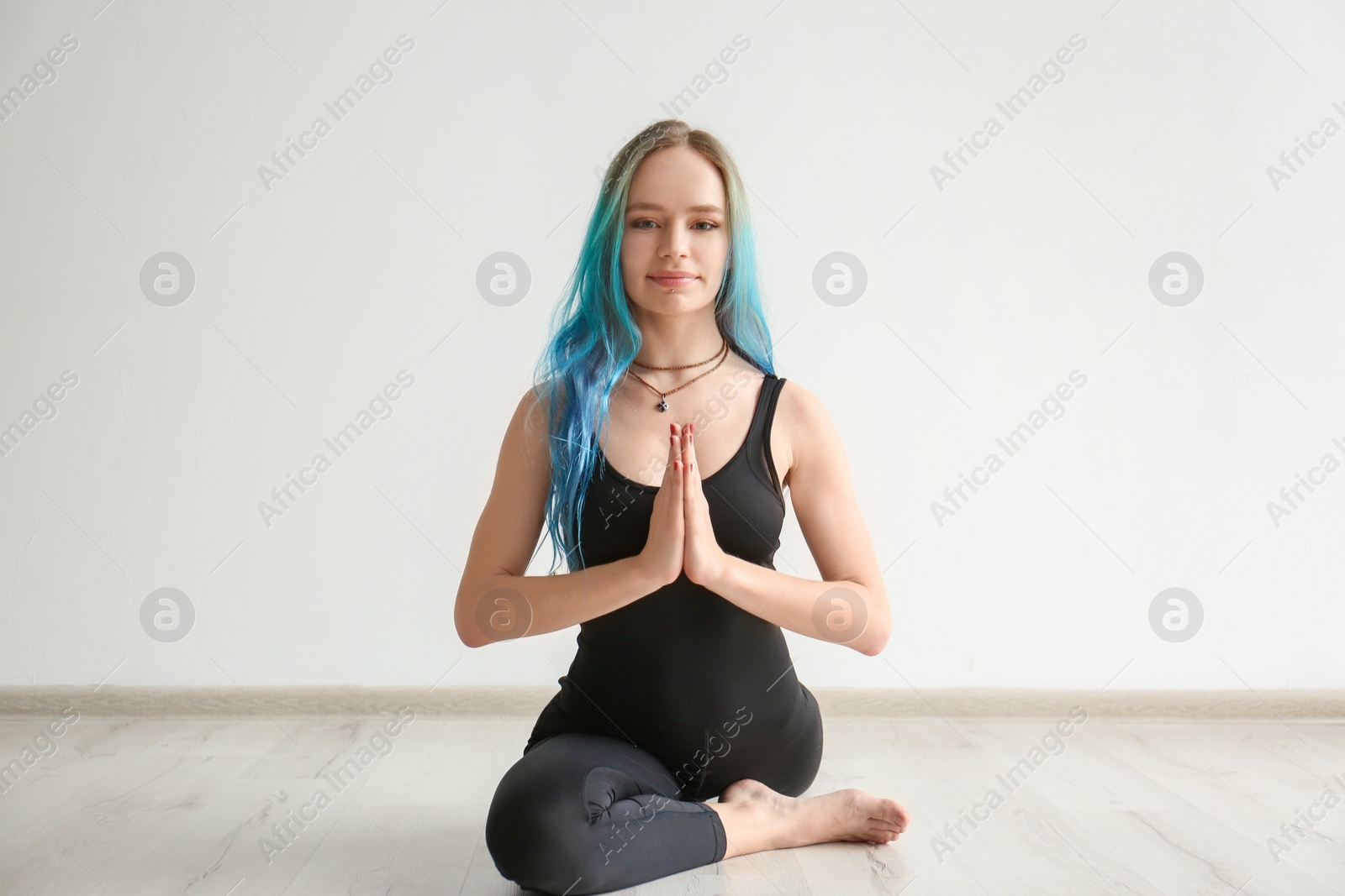 Photo of Young woman practicing yoga indoors