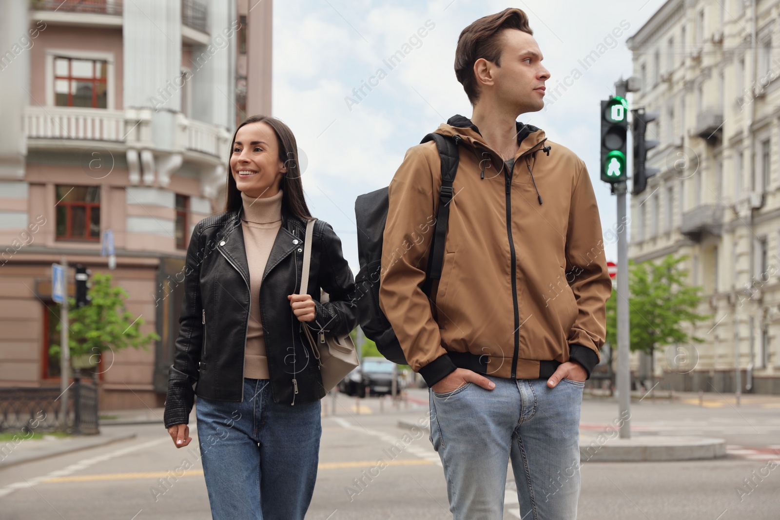 Photo of Young people crossing street at traffic lights