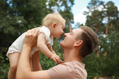 Photo of Father with his cute baby spending time together outdoors