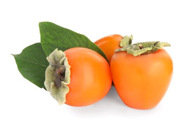 Photo of Delicious persimmons and green leaves isolated on white