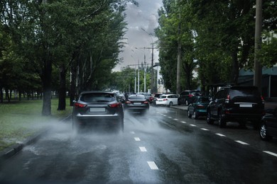 Photo of View of city road with cars on rainy day