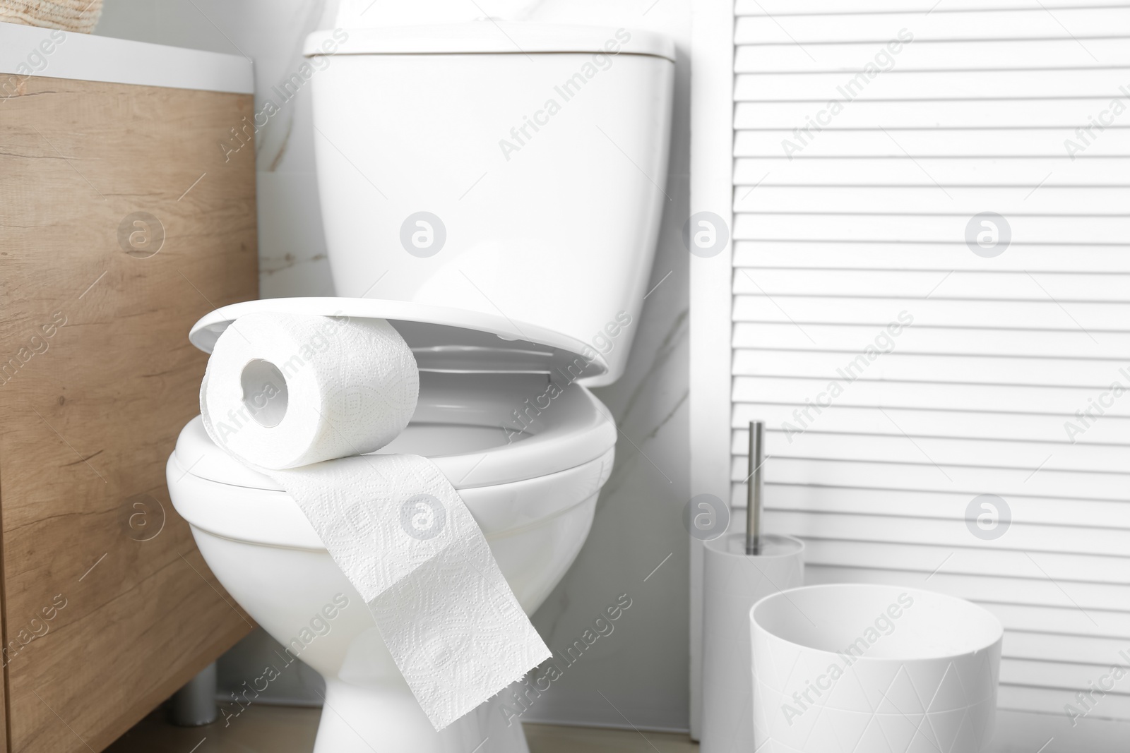 Photo of New paper roll on toilet seat in bathroom