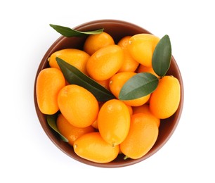 Fresh ripe kumquats with leaves in bowl on white background, top view. Exotic fruit