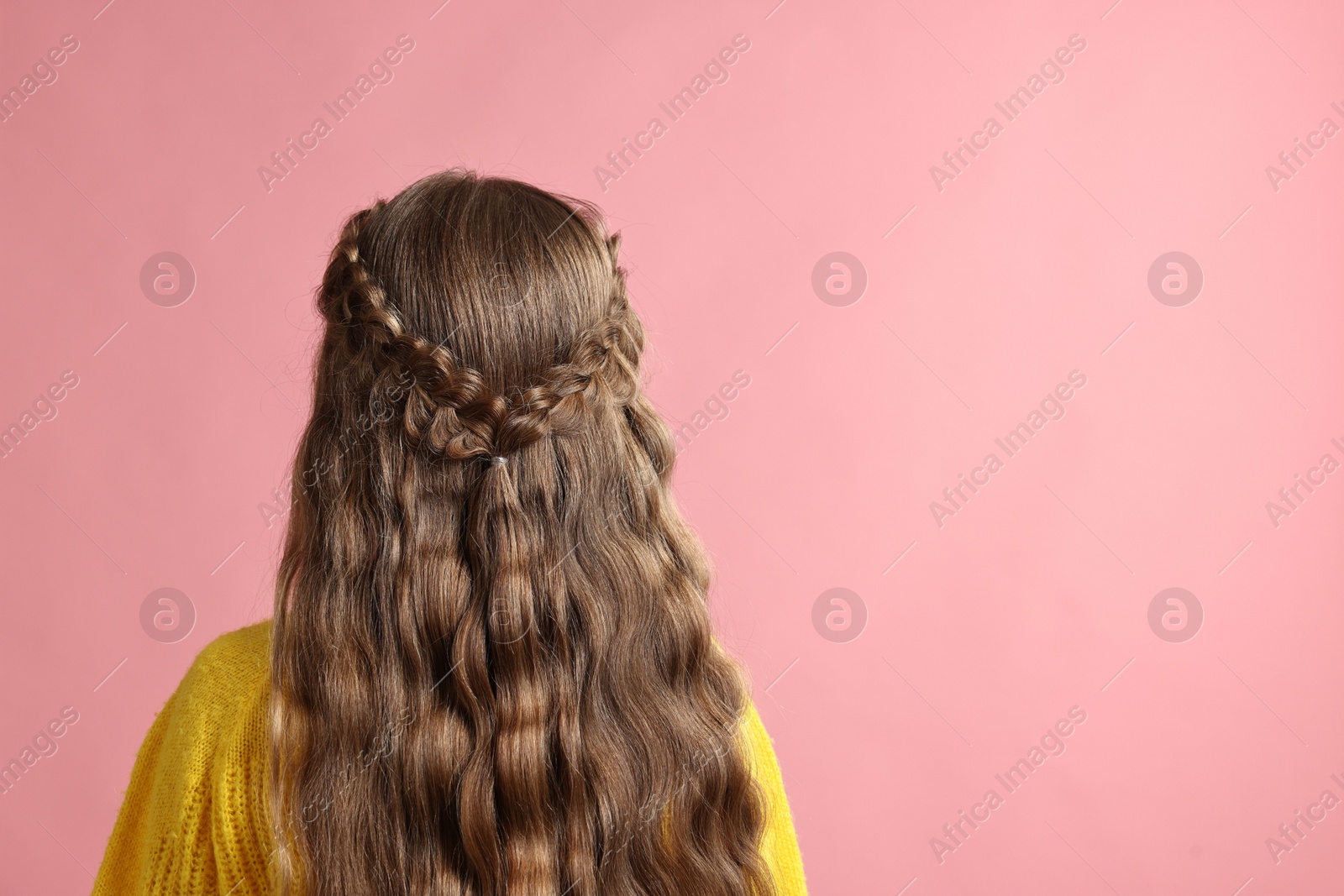 Photo of Little girl with braided hair on pink background, back view. Space for text