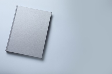 Closed grey book with hard cover on white background, top view