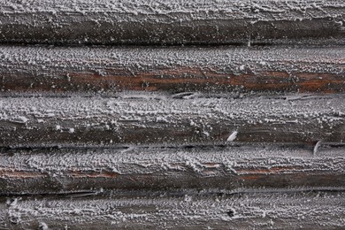 Wooden wall covered with hoarfrost on snowy day, closeup