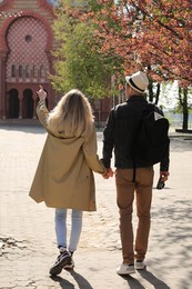 Photo of Couple of tourists walking on city street