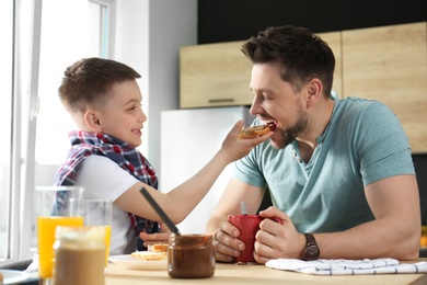 Photo of Dad and son having breakfast together in kitchen