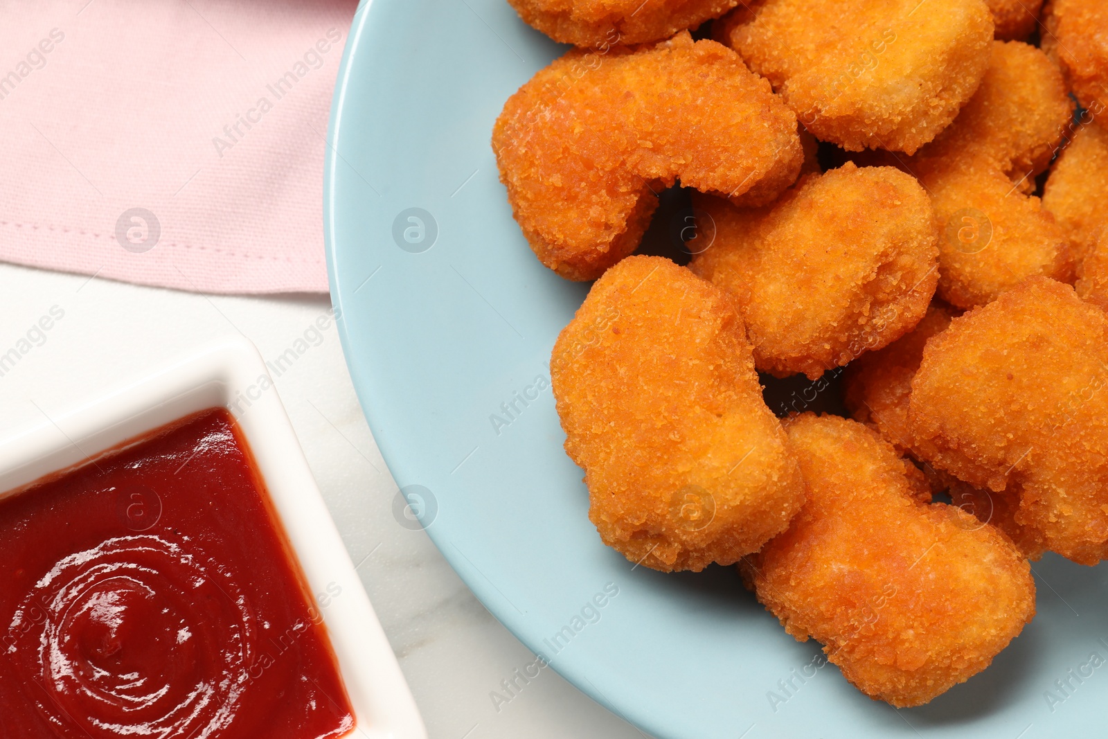 Photo of Tasty ketchup and chicken nuggets on table, flat lay