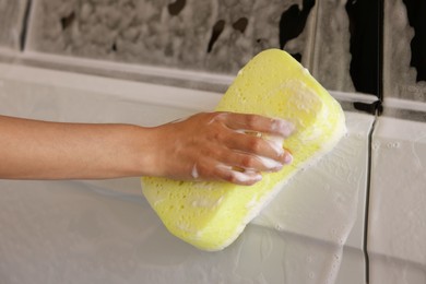 Woman washing car with sponge, closeup view