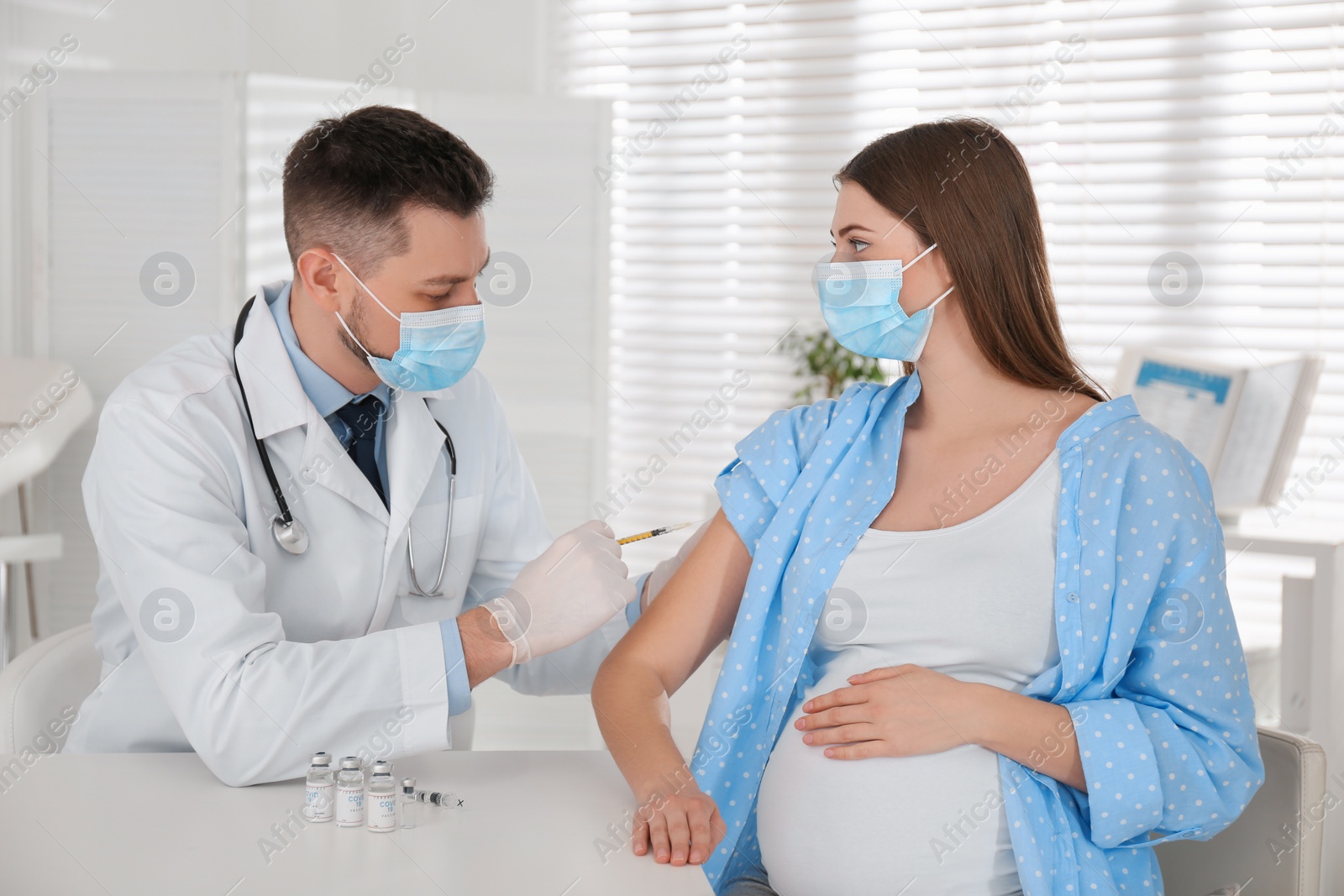 Photo of Doctor vaccinating pregnant woman against Covid-19 in clinic