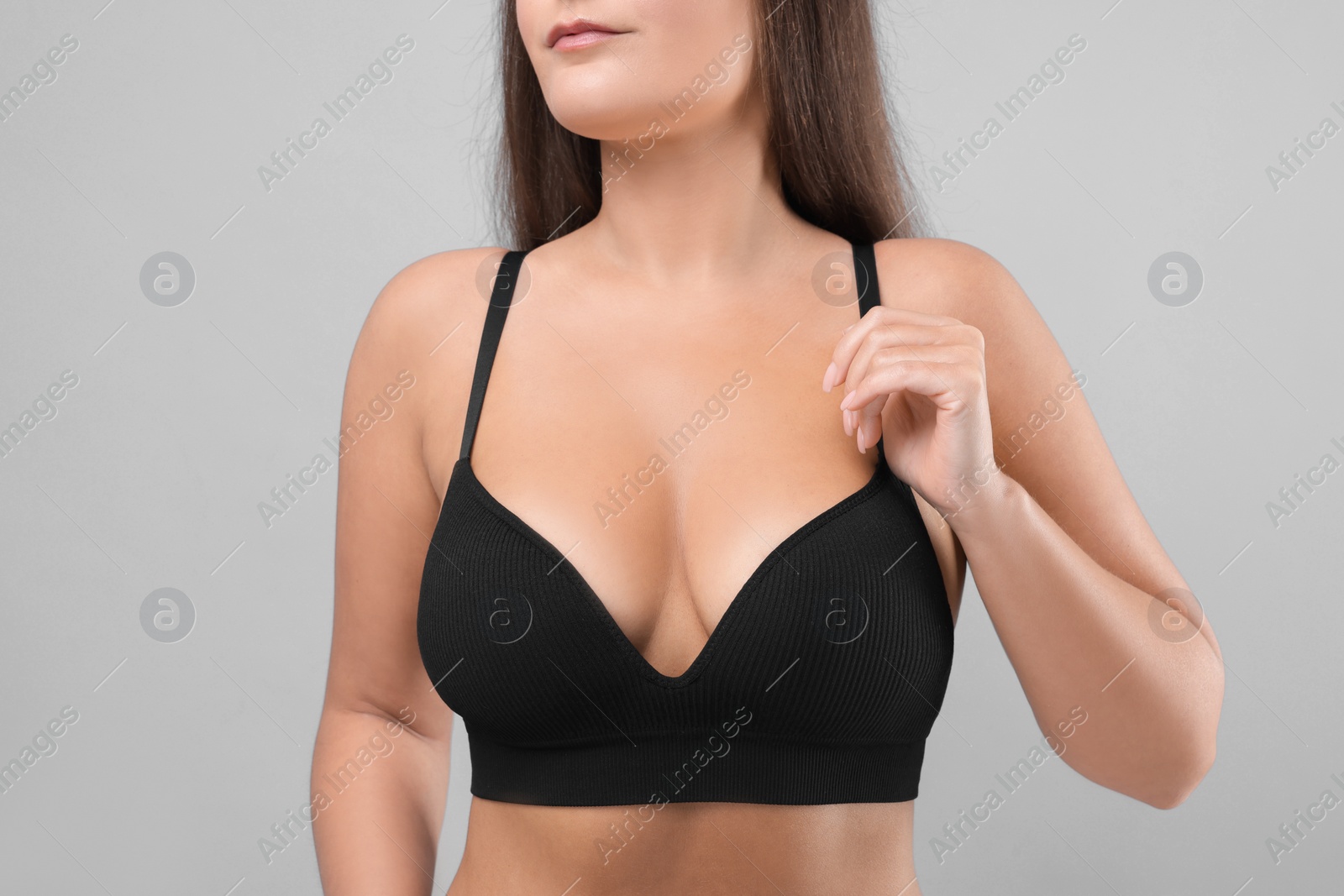 Photo of Woman with beautiful breast on light grey background, closeup