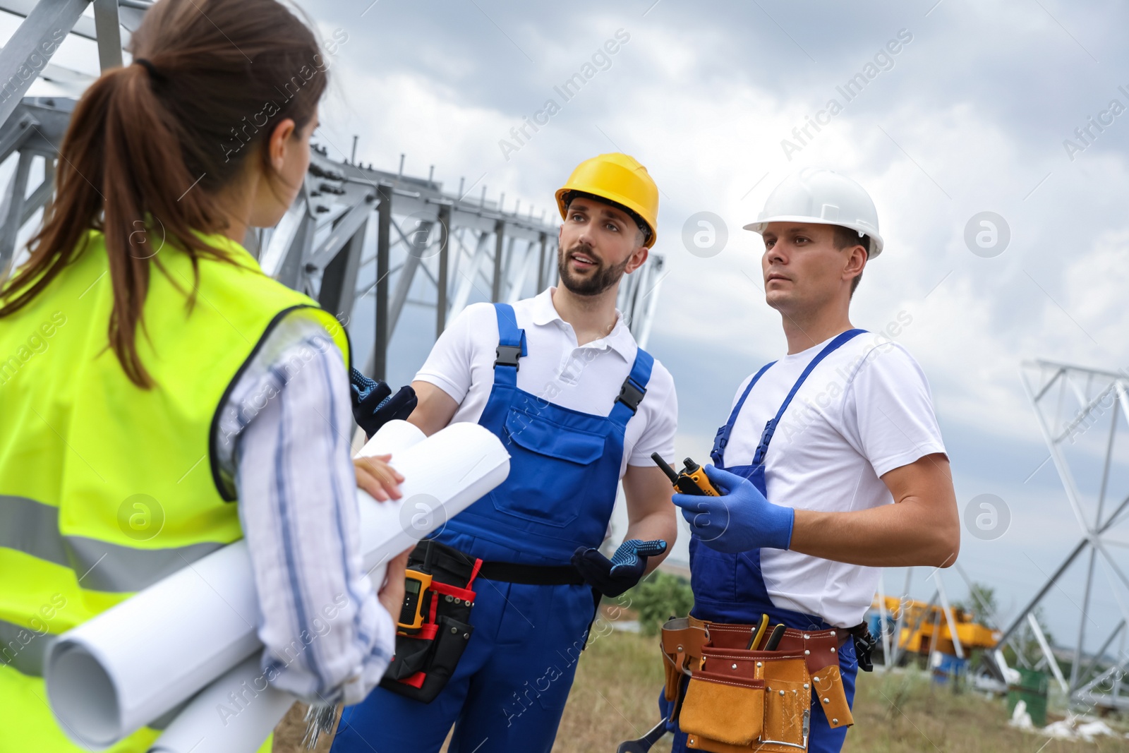 Photo of Professional engineers working on installation of electrical substation outdoors