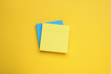 Paper notes on yellow background, top view