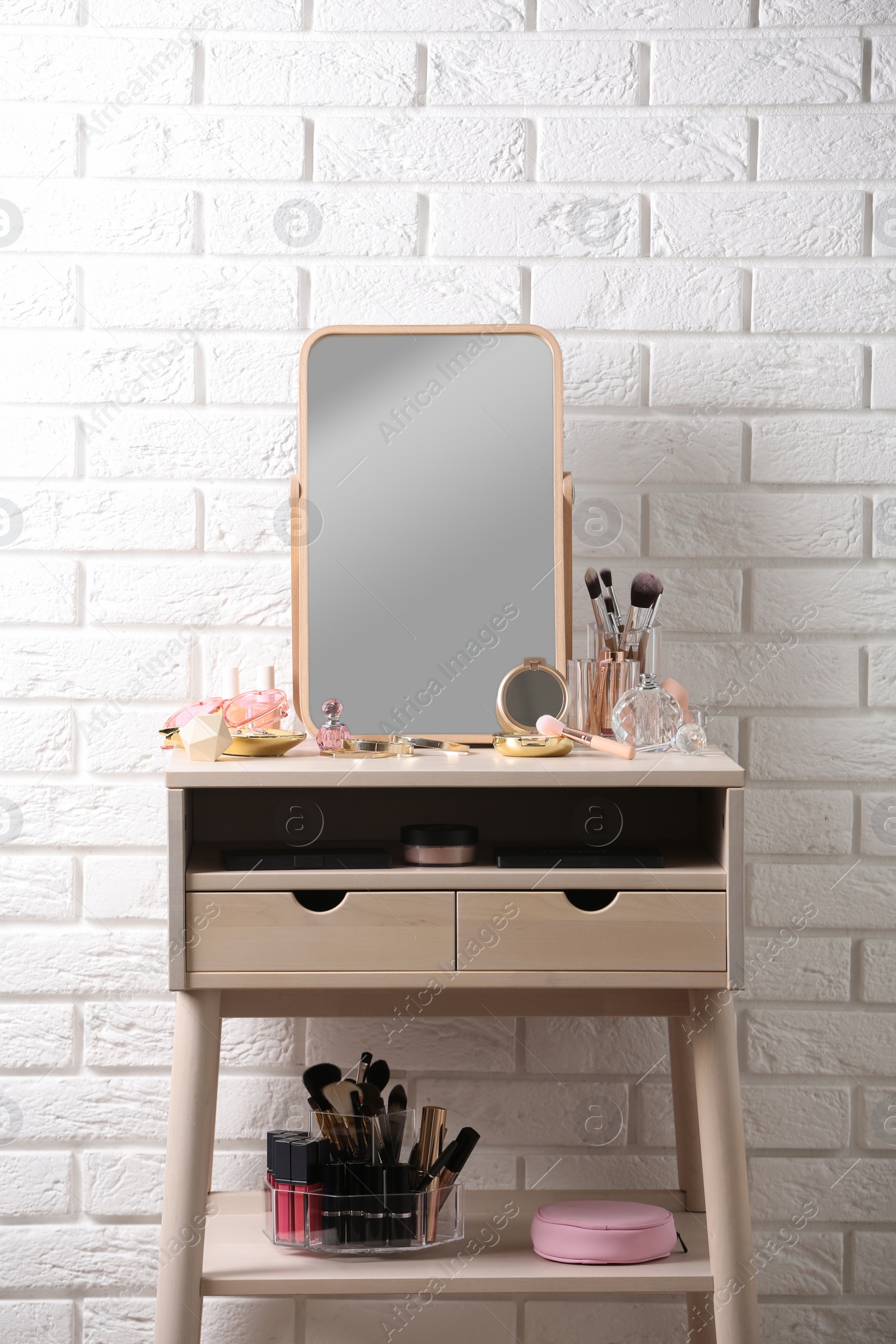 Photo of Dressing table with different makeup products and accessories in room interior