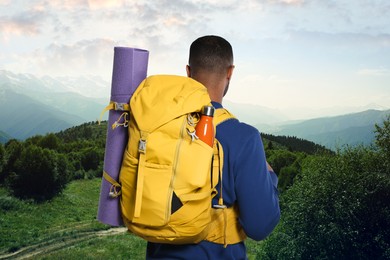 Image of Tourist with backpack in mountains, back view