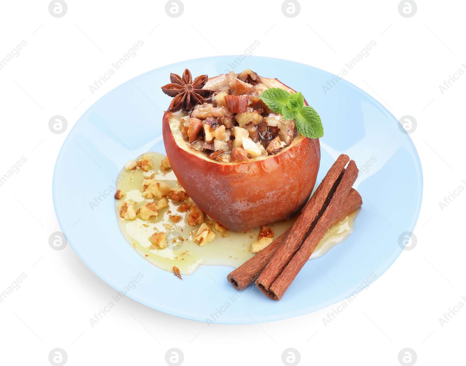 Photo of Tasty baked apple with nuts, honey, spices and mint isolated on white