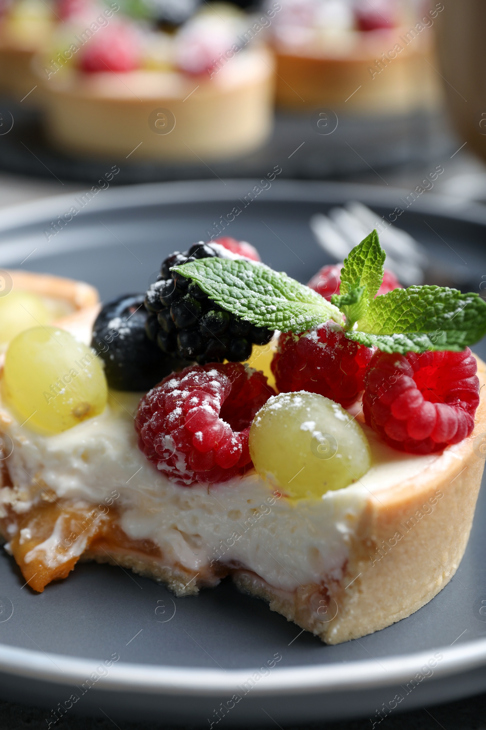 Photo of Delicious tartlet with berries on plate, closeup