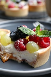 Photo of Delicious tartlet with berries on plate, closeup