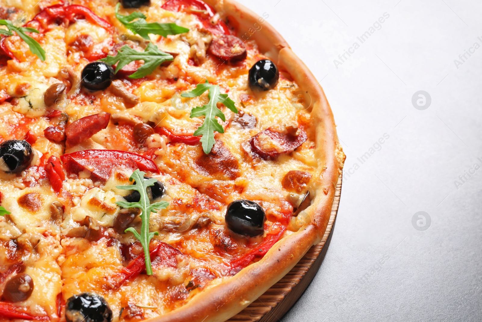 Photo of Delicious pizza with olives and sausages on table