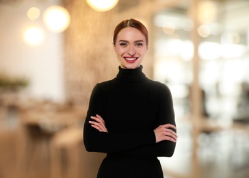 Image of Portrait of happy woman in office. Pretty girl looking at camera and smiling on blurred background