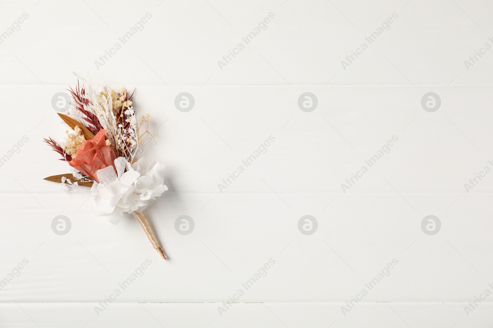 Photo of Beautiful boutonniere on white background, top view. Space for text