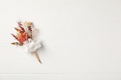 Photo of Beautiful boutonniere on white background, top view. Space for text