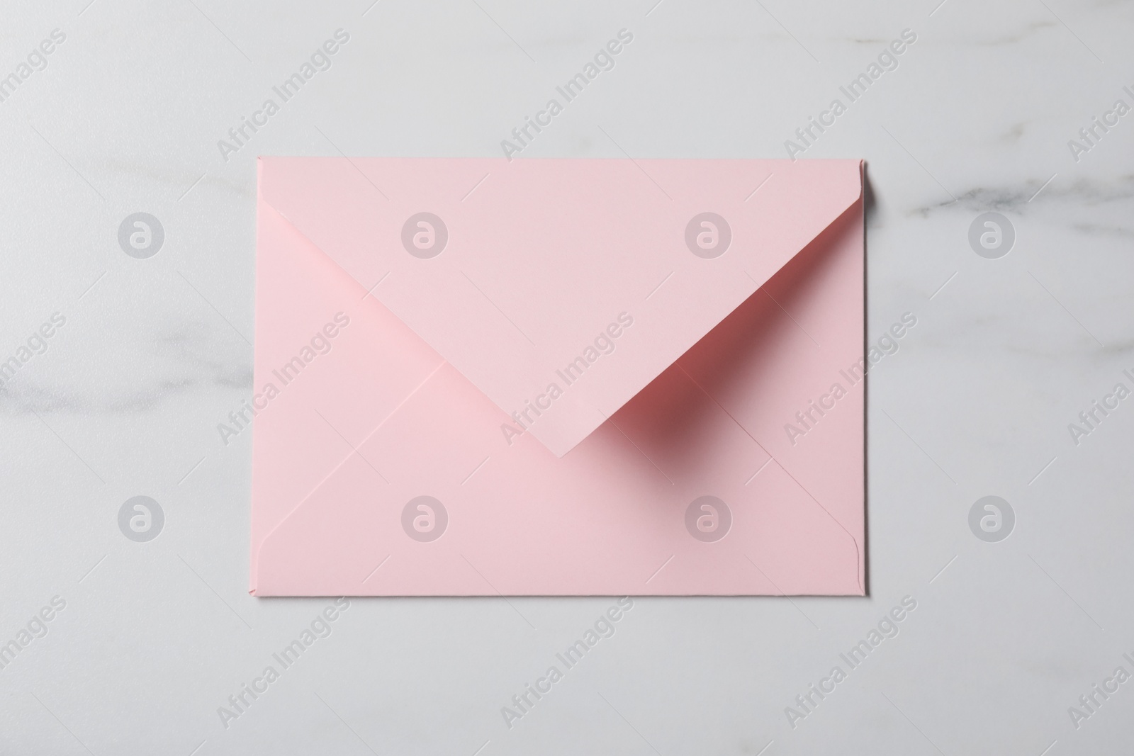 Photo of Letter envelope on white marble table, top view