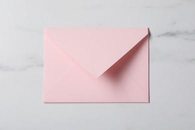 Letter envelope on white marble table, top view