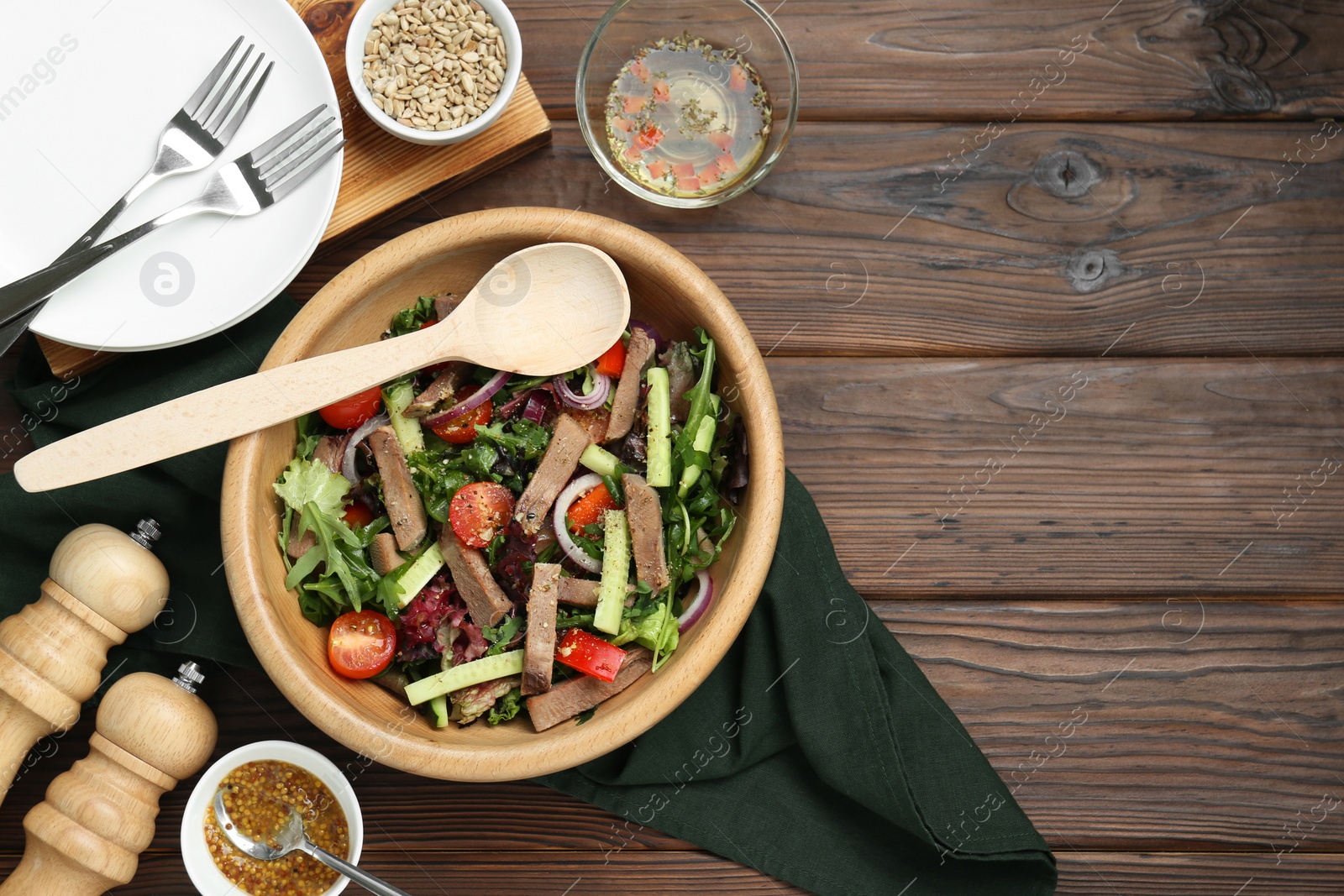 Photo of Delicious salad with beef tongue, vegetables and spoon served on wooden table, flat lay. Space for text