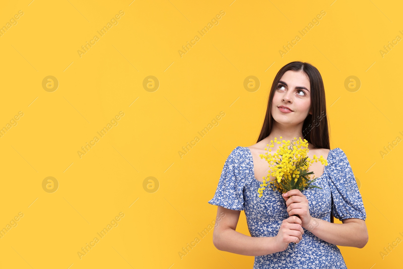 Photo of Happy young woman with beautiful bouquet on orange background. Space for text