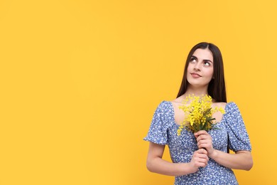 Photo of Happy young woman with beautiful bouquet on orange background. Space for text