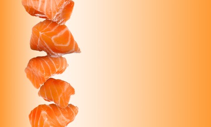 Image of Cut fresh salmon falling on white and orange gradient background, space for text