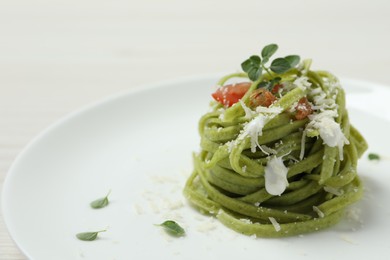 Tasty tagliatelle with spinach and cheese on plate, closeup. Exquisite presentation of pasta dish