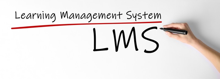 Image of Woman writing abbreviation LMS below underlined Learning Management System text on whiteboard, closeup. Banner design