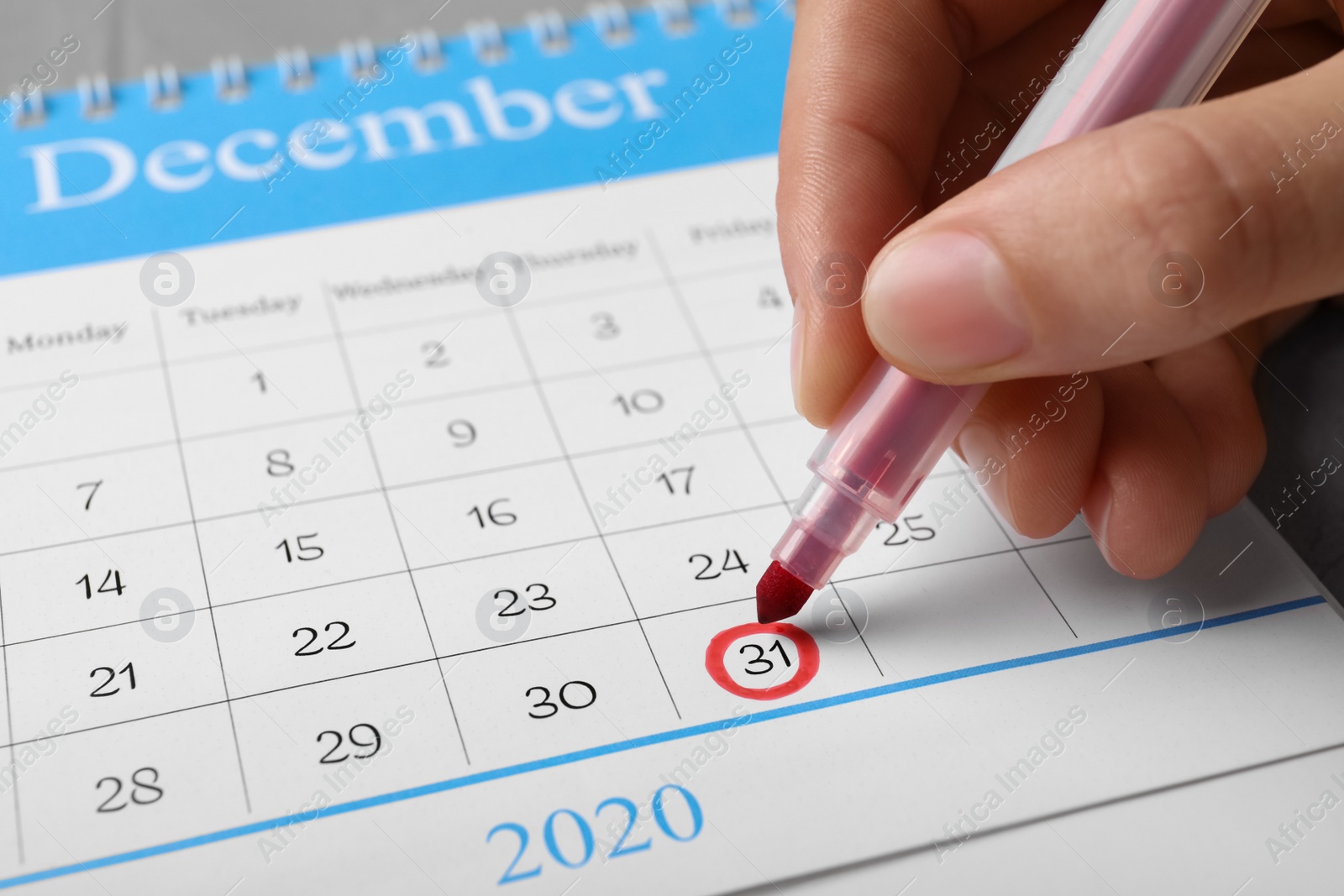 Photo of Woman marking date in calendar, closeup. New Year countdown