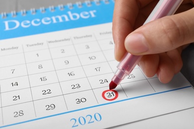 Woman marking date in calendar, closeup. New Year countdown