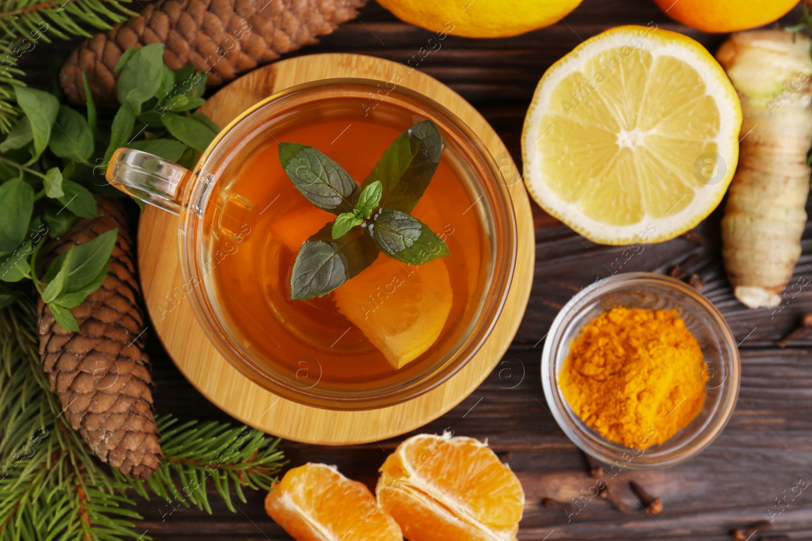 Photo of Flat lay composition with glass cup of delicious immunity boosting tea and ingredients on wooden table