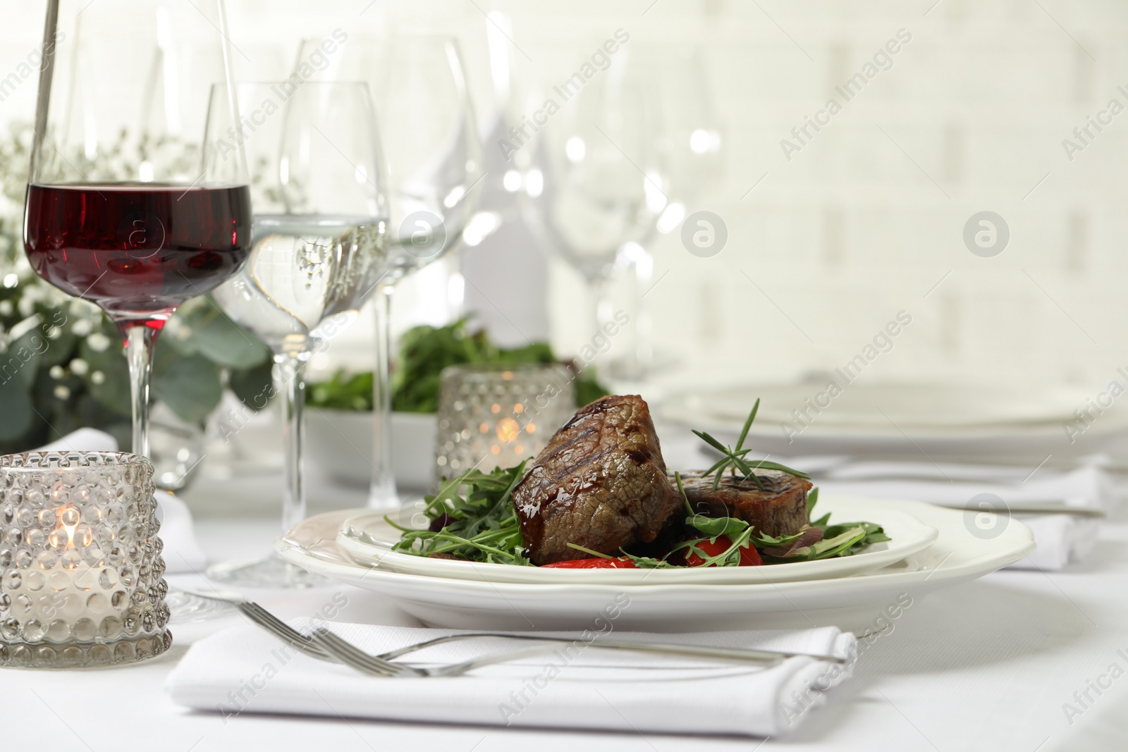 Photo of Delicious grilled meat with vegetables and wine served on table in restaurant