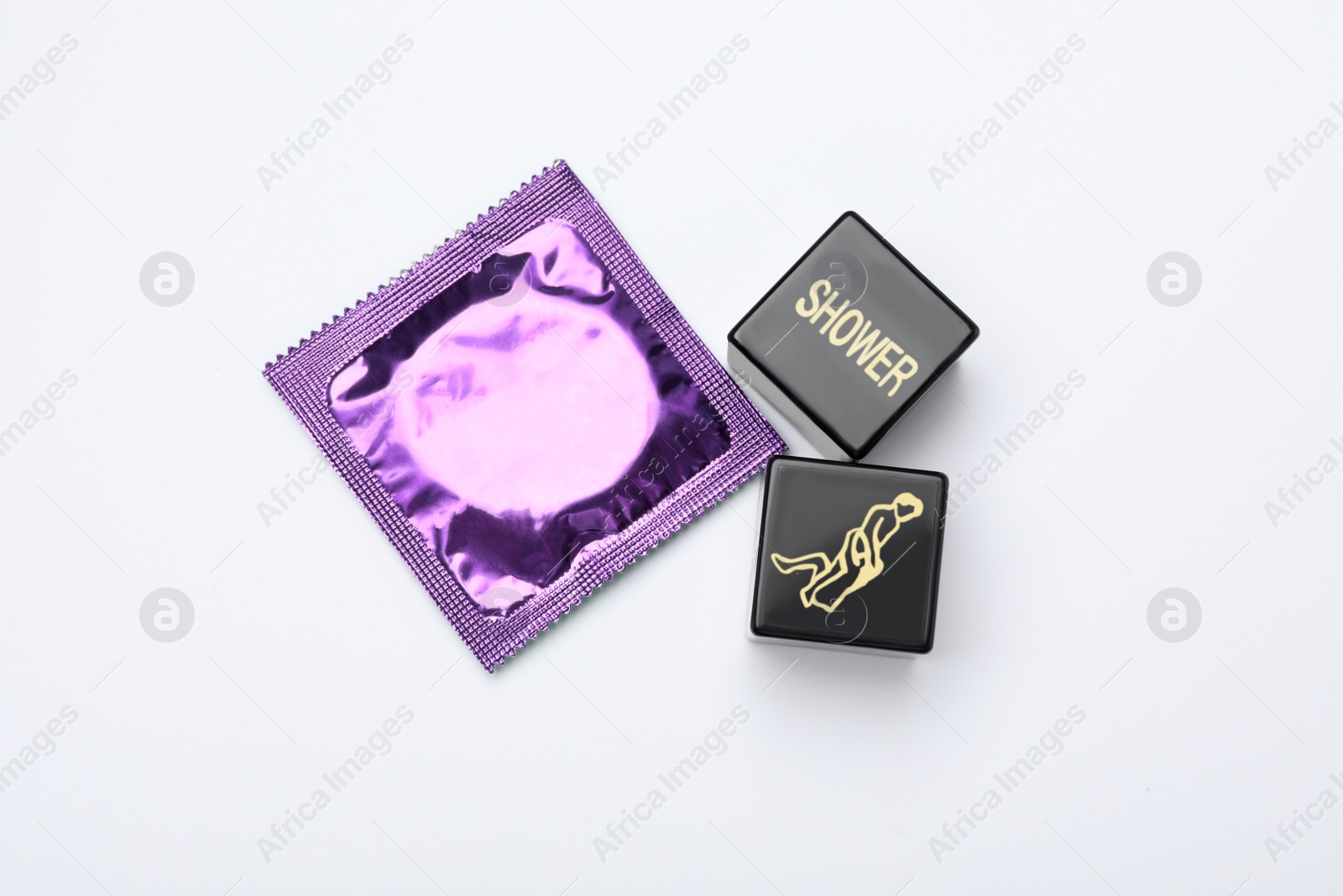 Photo of Sex dice and condom on white background, top view