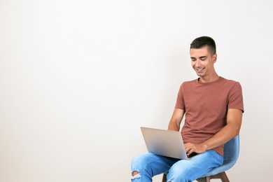 Photo of Man in casual clothes with laptop on color background