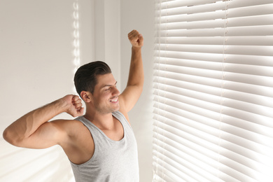 Photo of Man near window in bedroom. Lazy morning