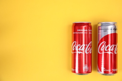 MYKOLAIV, UKRAINE - NOVEMBER 14, 2018: Coca-Cola cans on color background, top view. Space for text