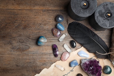 Photo of Flat lay composition with different gemstones on wooden background. Space for text