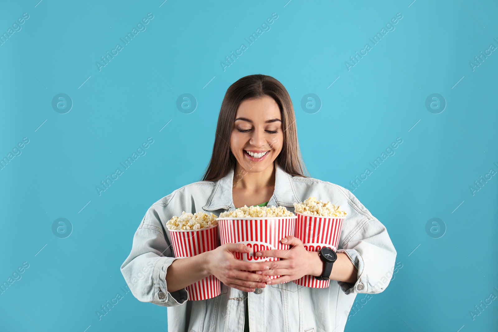 Photo of Young woman with tasty popcorn on color background