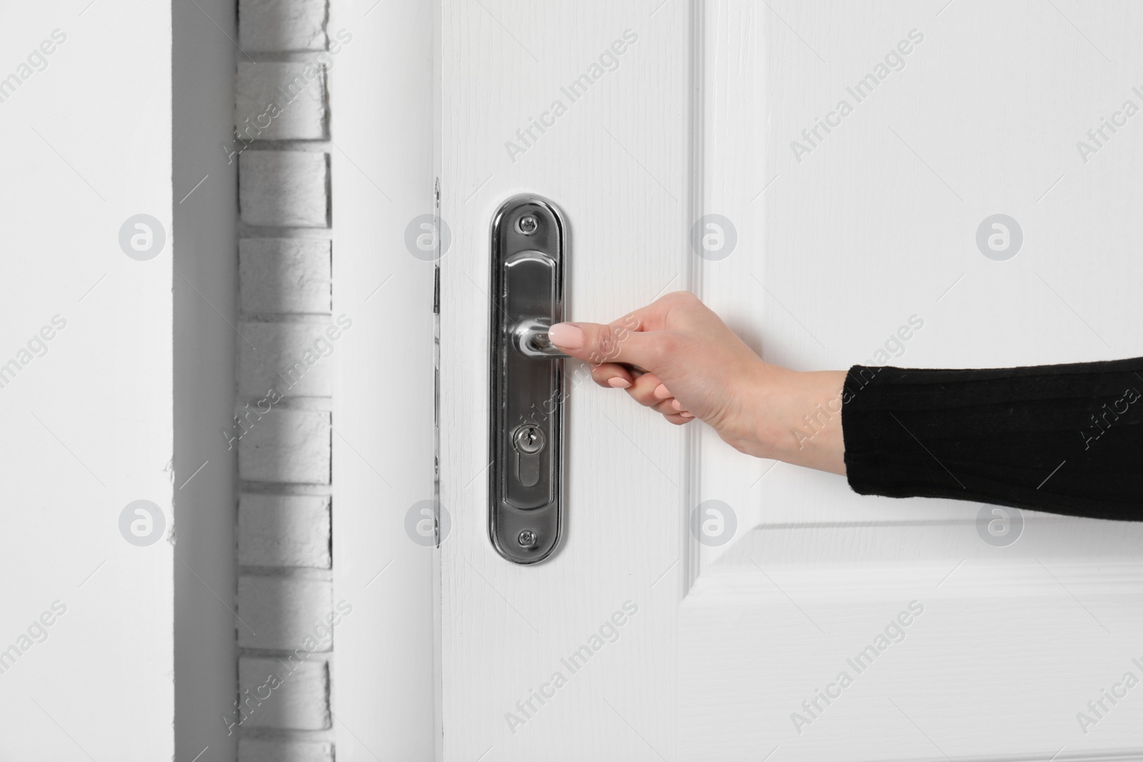 Photo of Woman opening white wooden door, closeup view