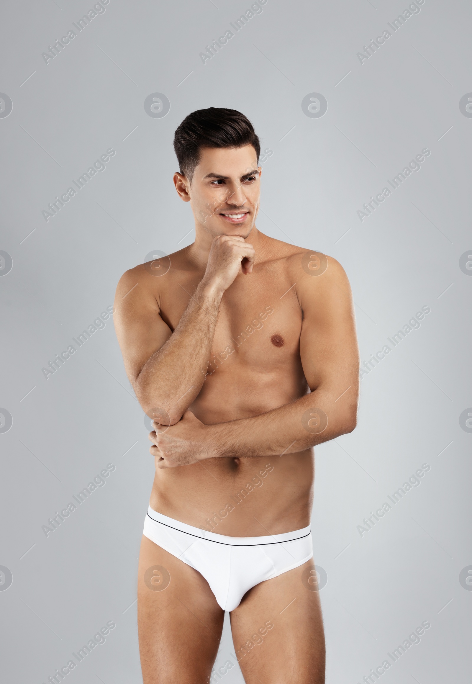 Photo of Handsome man in white underwear on light grey background